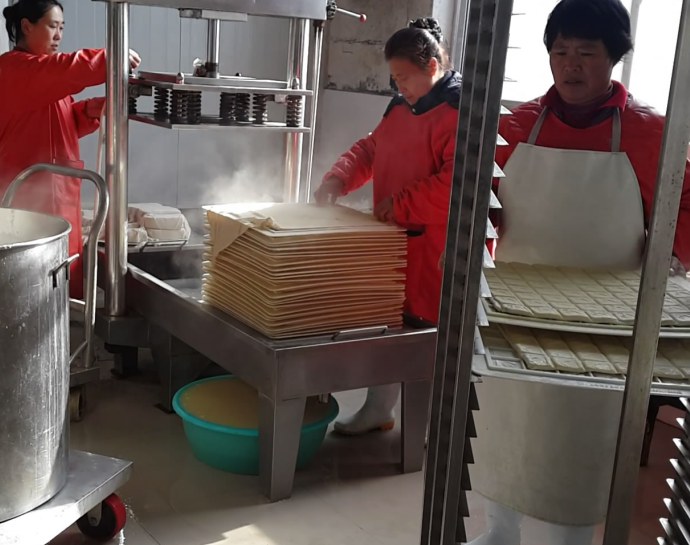豆皮機(jī)加工廠流水線作業(yè)